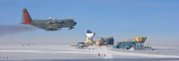 A LC-130 aircraft is passing the NSF South Pole station Dark Sector during take off.  CMB telescopes visible in the background include (left to right) the South Pole Telescope, the BICEP2 telescope, and the Keck Array telescope. (<i>Steffen Richter, Harvard University</i>)